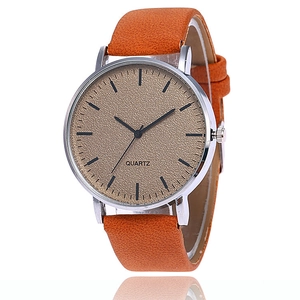 Détail macro d'une montre à quartz pour homme avec bracelet en cuir orange et cadran sablé