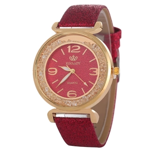 Dettaglio ravvicinato dell'orologio con quadrante rosso glitter e cassa dorata