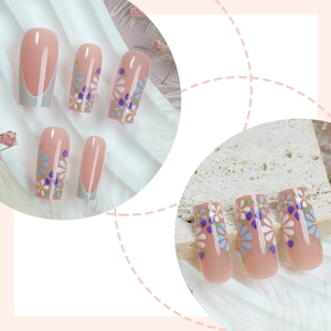 French tip press-on nails in nude pink with colorful hand-painted floral daisy designs