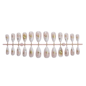 French almond press-on nails with nude pink gradient, gold stars, and rhinestones