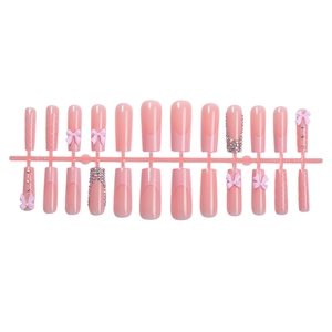 Pink press-on nails set with 3D bows and rhinestones in long coffin shape design