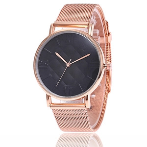 Détail d'une montre en maille or rose avec cadran noir texturé et chiffres romains élégants