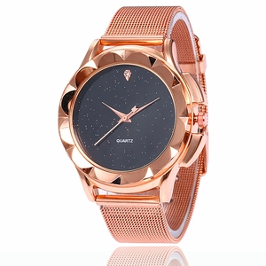 Détail macro du cadran étoilé et du boîtier pétale or rose sur une montre à quartz
