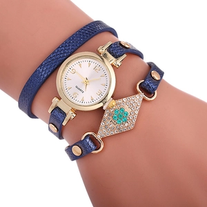 Détail d'une montre à bracelet bleu serpent avec rivets et décor floral turquoise