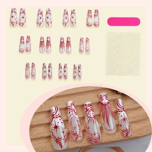 Long trapezoid press-on nails set with red moon and star patterns on white base