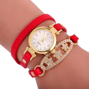 Détail de la montre multi-tours en cuir rouge avec cadran doré et fleurs en strass