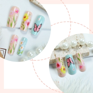 Pastel floral press-on nails with pink and blue hand-painted flower and butterfly designs