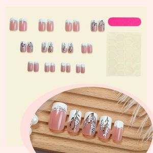 Floral French press-on nails set with pink tips and hand-painted white flower designs