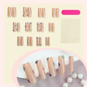 Pink coffin press-on nails set with floral rhinestone accents and application tools