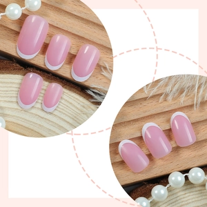 Unghie finte corte ovali rosa nude con punte french bianche su sfondo in legno naturale