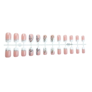 Pink and white French press-on nails with floral painted designs and glitter accents