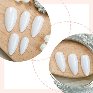 Glossy white almond shaped press-on nails set on minimalist light wood background