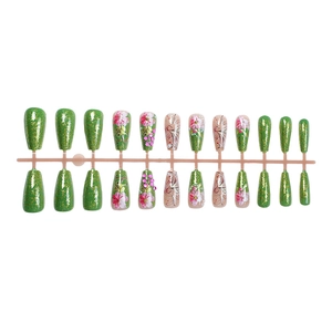 Green glitter press-on nails with floral patterns and pink rhinestones on a white background