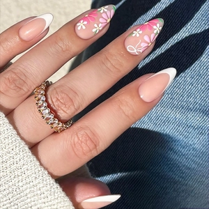Detail of almond-shaped press-on nails with floral patterns and French tips