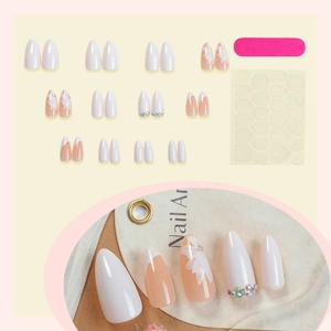 Almond press-on nail kit with white floral designs and rhinestones on nude base