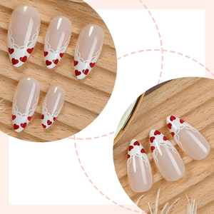 French tip almond press-on nails with red heart patterns and white lace designs