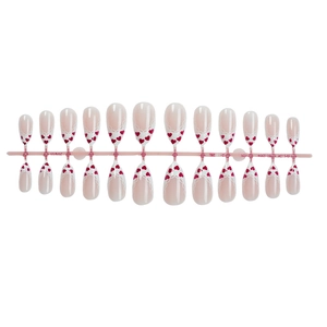 French tip press-on nails with white lace edges and red heart patterns on pink base