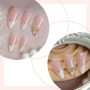 Faux ongles amande avec bordure dorée française et nœuds dorés 3D élégants