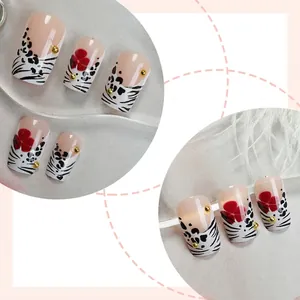 French leopard print press-on nails with red flowers and golden beads on gray background