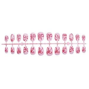 Pink oval press-on nails with red bow patterns, 24 pieces set on a production rack