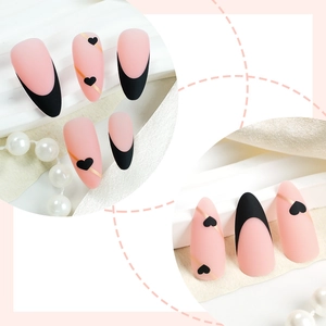 Matte almond press-on nails with black heart patterns and French tips on silk background