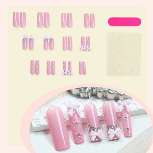 Pink long ballerina press-on nails with 3D bows, rhinestones and criss-cross patterns