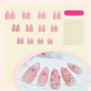 Pink almond press-on nails with 3D floral accents, butterfly designs, and rhinestones