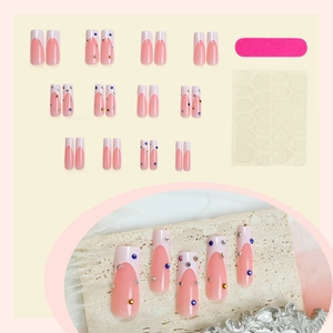French tip press-on nails with pink gradient and rhinestones, plus DIY toolkit