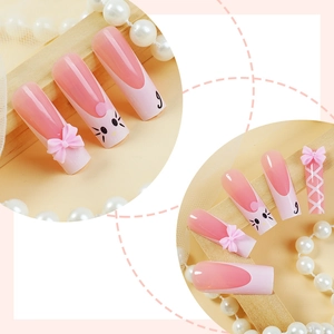 Detail of pink French coffin press-on nails with 3D bow and cute cat face art