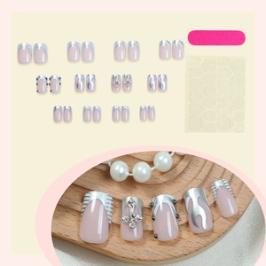 Pink press-on nail kit with silver cross and flame design including glue and file