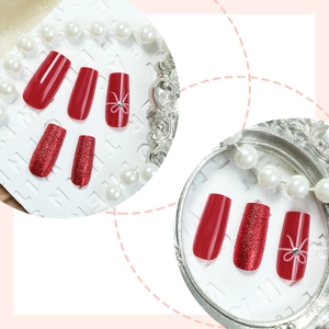 Long coffin Christmas press-on nails in glitter red with white bow and rhinestone accents