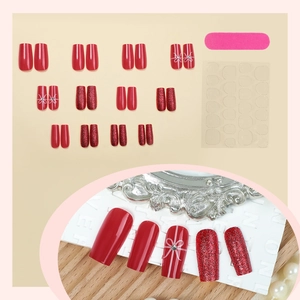 Christmas red glitter press-on nails set with white bow designs and manicure tools