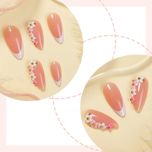 Long almond press-on nails with white French tips and 3D floral relief with gold beads