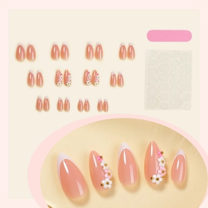 Long almond press-on nails with white French tips, 3D floral accents, and tool kit