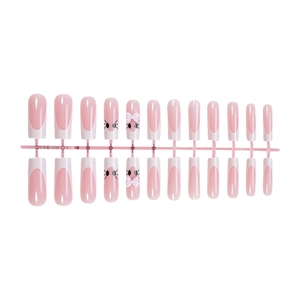 Close-up of pink handmade press-on nails with 3D bows, dots, and French tips detail