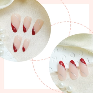 Almond press-on nails with frosted pink base, red french tips, and silver glitter star accents