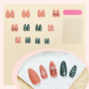 Christmas almond press-on nails featuring reindeer, green glitter, and snowflake designs