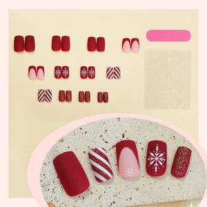 Christmas press-on nails with red glitter, white snowflakes, and candy cane stripes