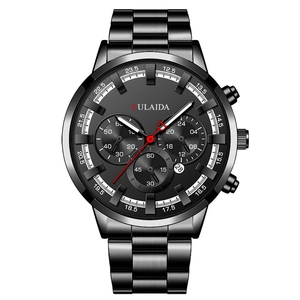Macro shot of black chronograph watch with luminous hands and a red second needle