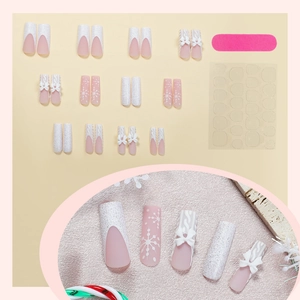 Christmas press-on nails with pink snowflake patterns and 3D sweater texture bows