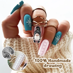 Detail of handmade Christmas press-on nails with blue snowflake and pink knit texture