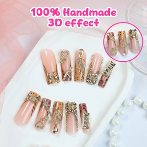 Faux ongles faits main motif léopard avec nœud doré 3D et détails en strass