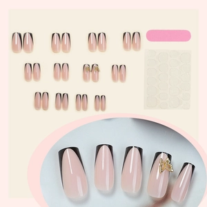 French tip press-on nails in black and nude with 3D gold butterfly accents and tools