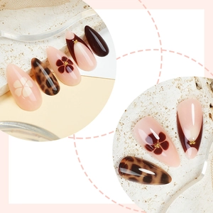 Almond leopard print press-on nails with floral motifs and gold beads in brown tones