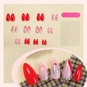 Christmas almond press-on nails with red glitter, deer antlers, and festive rhinestones