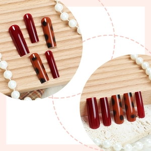 Long trapezoid press-on nails in deep red and amber leopard pattern with glossy finish