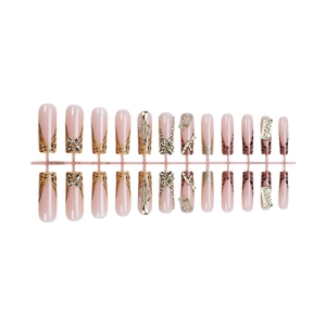 Faux ongles léopard roses avec nœuds dorés 3D et cristaux sur fond blanc épuré