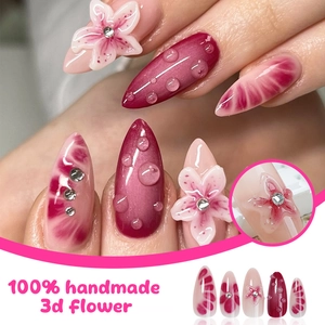 Dettaglio delle unghie finte 3D con fiori rosa, strass ed effetto goccia d'acqua