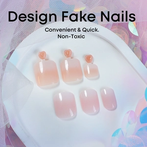 Macro detail of pink gradient press-on toenails with heart charms on white tray