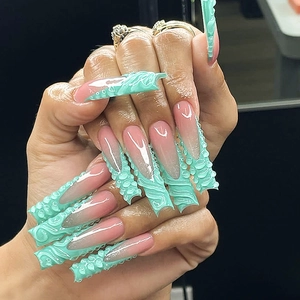 Detail of long press-on nails featuring mint green 3D wave textures and 3D floral patterns